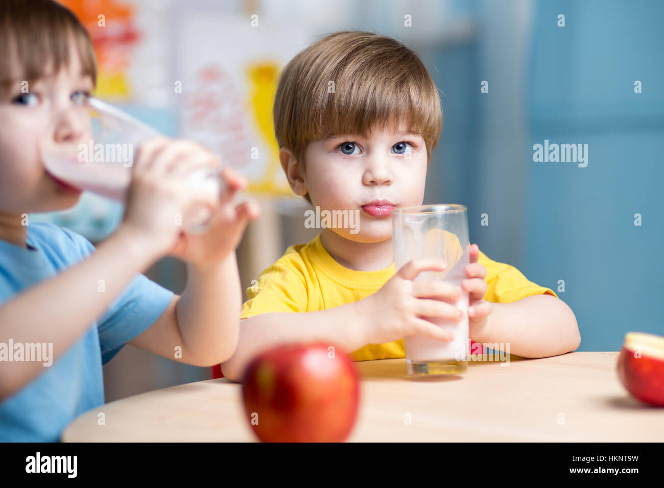 Kids boys drinking milk in nursery Stock Photo
