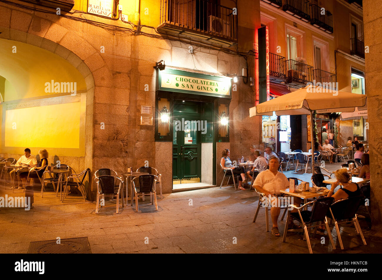 People sitting on the Chocolatería San Gines terrace, night view. Madrid. Spain. Stock Photo
