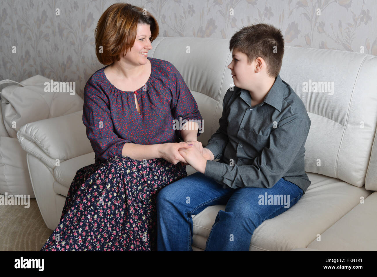 Mother and son hold hands and look at each other Stock Photo