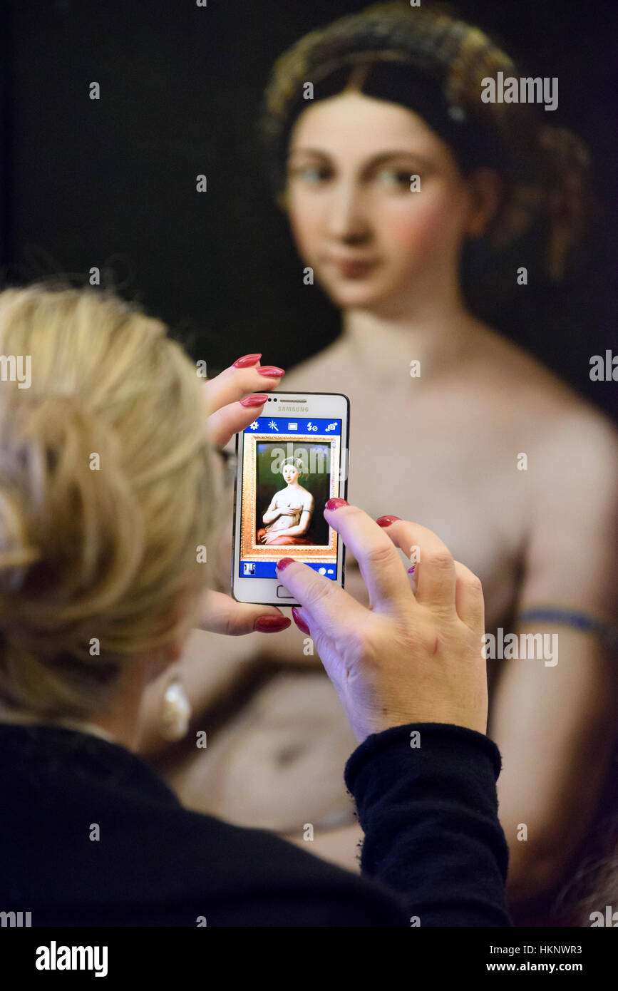Rome. Italy. Visitor using a cell phone to take a photo of La Fonarina by Rapahael in the Galleria Nazionale d'Arte Antica, Palazzo Barberini. Stock Photo