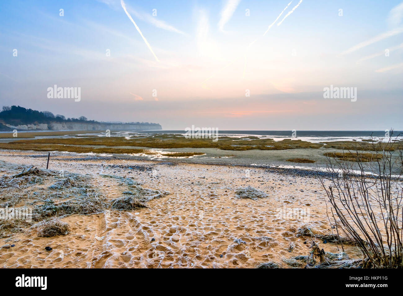 England, Ramsgate. Winter. Sunrise over the English Channel and Pegwell Bay. Frost on the beach, salt water marshes with spartina grass at low tide. Stock Photo