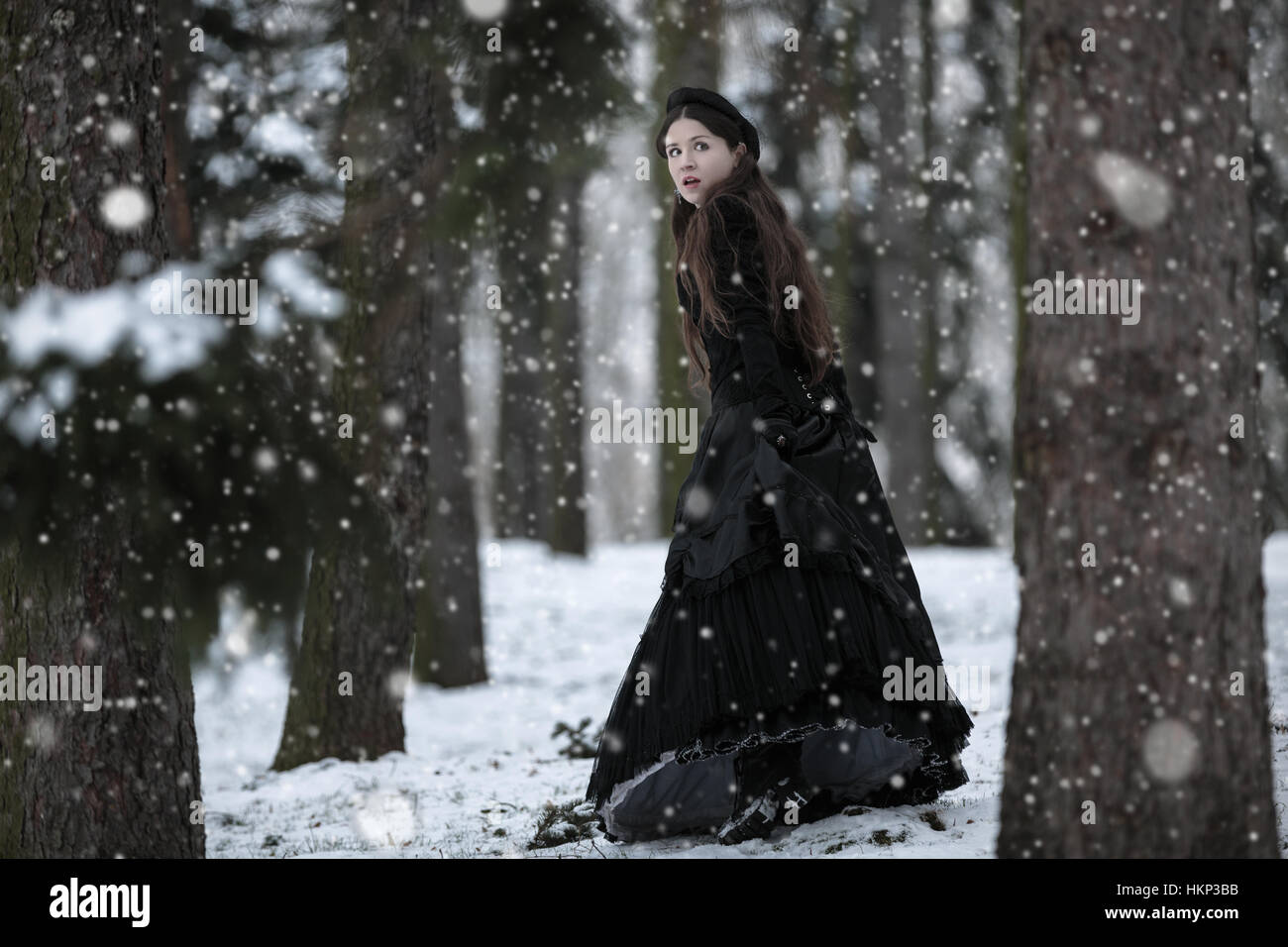 Woman in black Victorian dress in the winter park Stock Photo