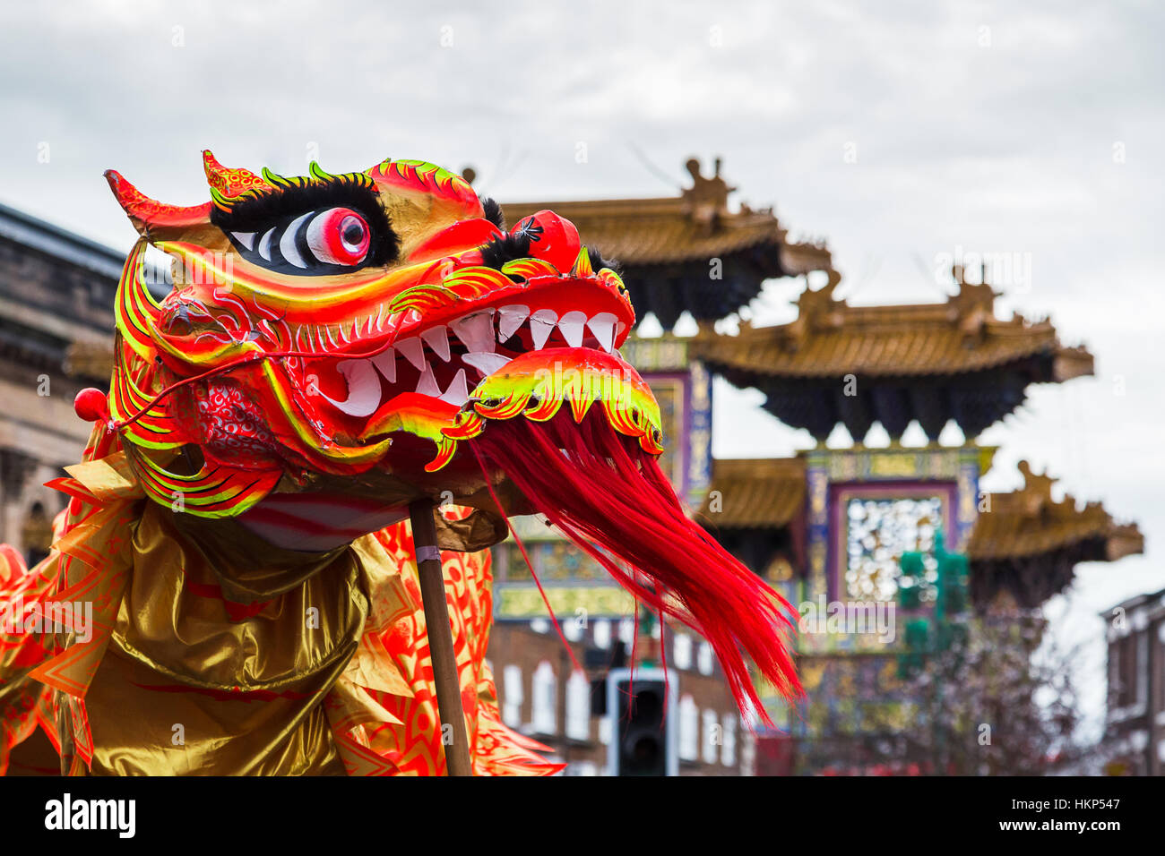 Close-up of orange and red coloured dragon in Liverpool's Chinatown chasing a pearl during Chinese New Year celebrations Stock Photo