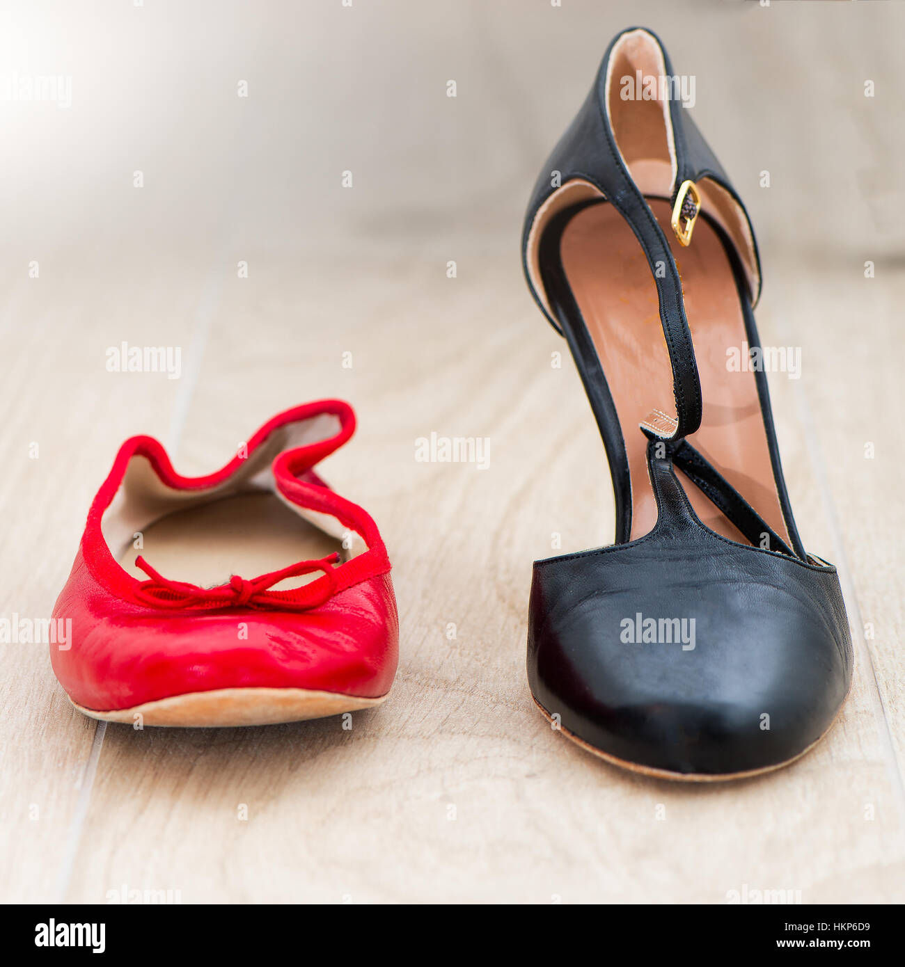 Red Shoes ballet flats and nearby black heels on withe background Stock Photo