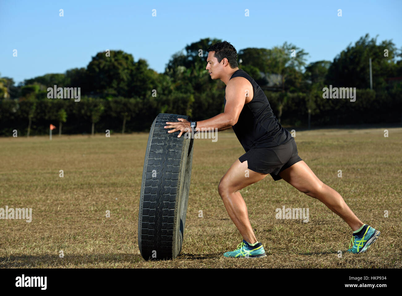 strongman flip big tire outdoor on  stadium grass Stock Photo