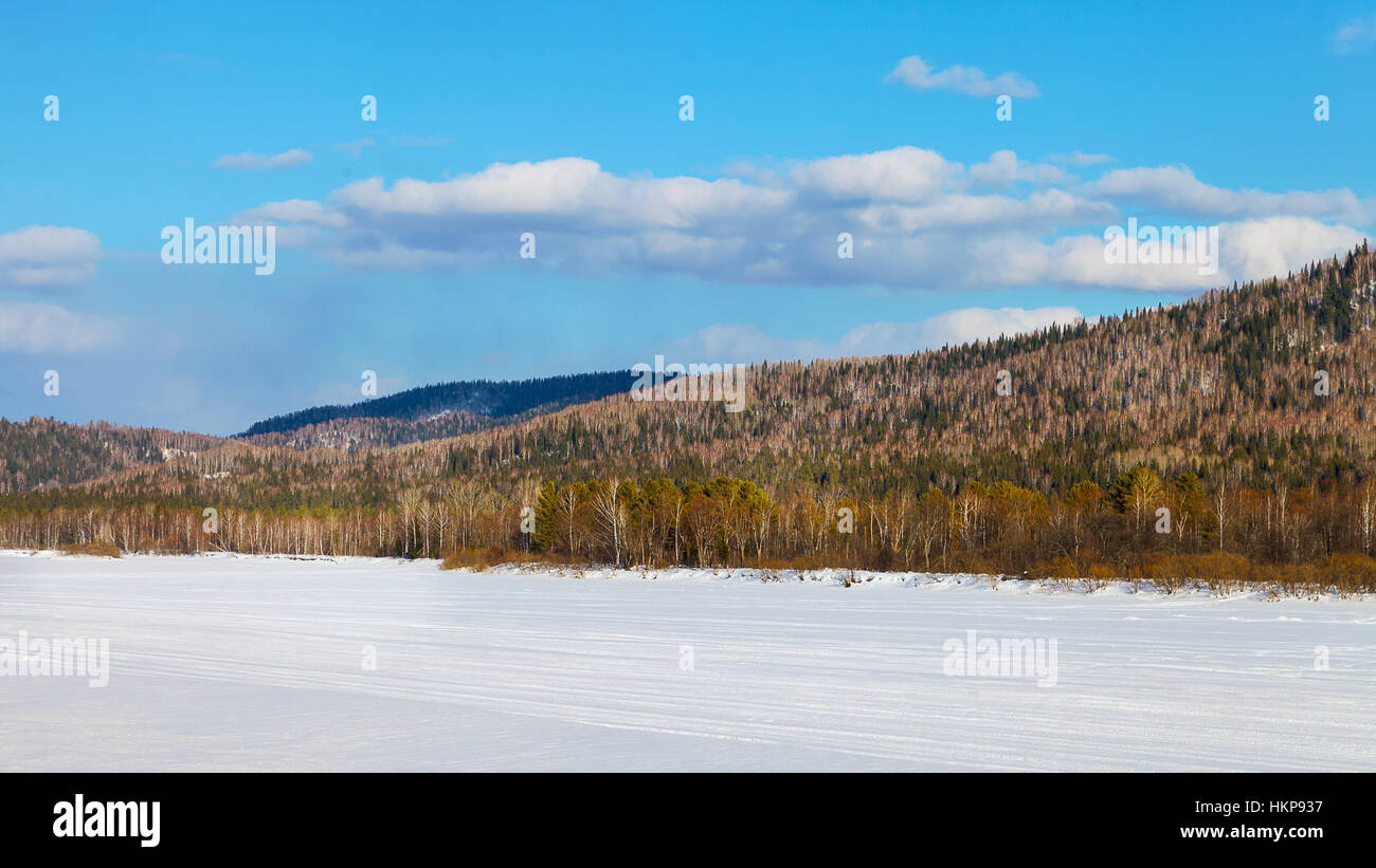 Beautiful landscape with ski run on frozen river.  Winter wonderland mountain scenery Stock Photo
