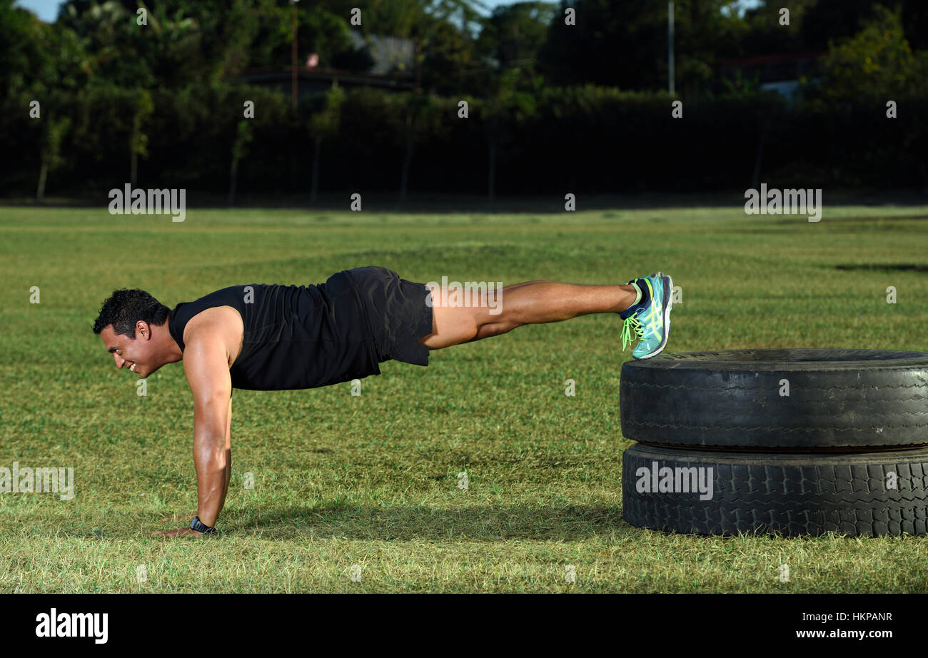 man in black doing push up on green grass park Stock Photo - Alamy