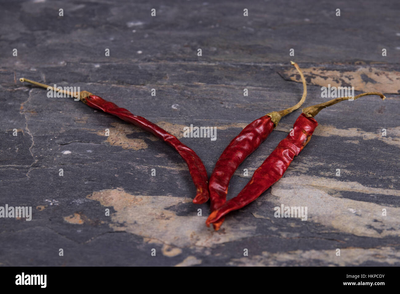 Dried red peppers on gray slate Stock Photo