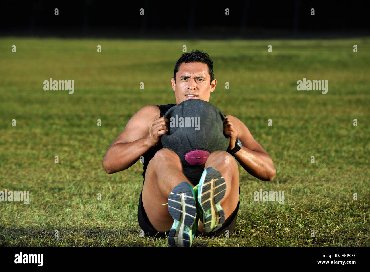 man workout on green grass with heavy ball Stock Photo Alamy