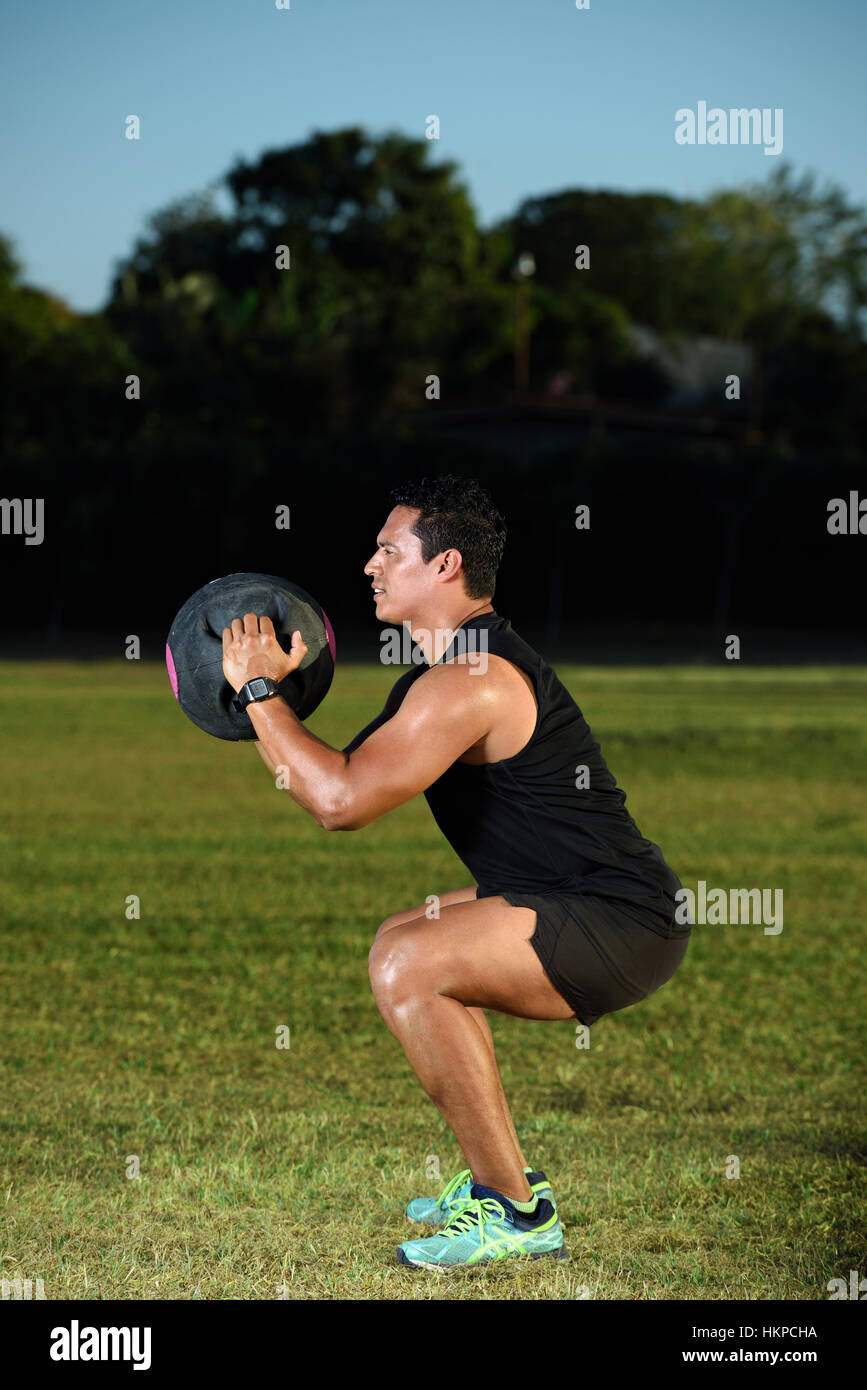 man working out with heavy ball on green grass park Stock Photo Alamy