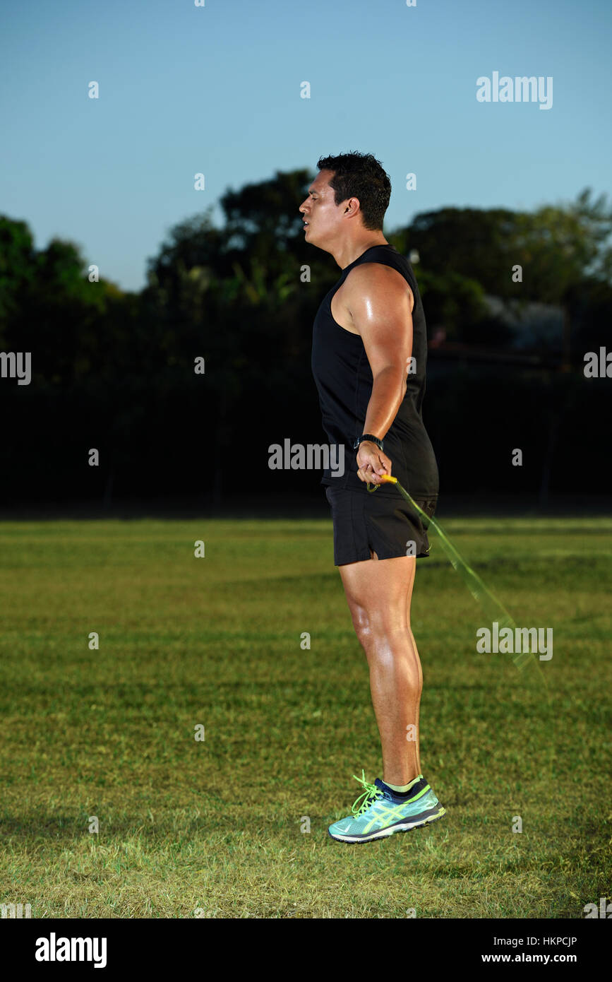 sport man jumping rope on green grass background Stock Photo Alamy