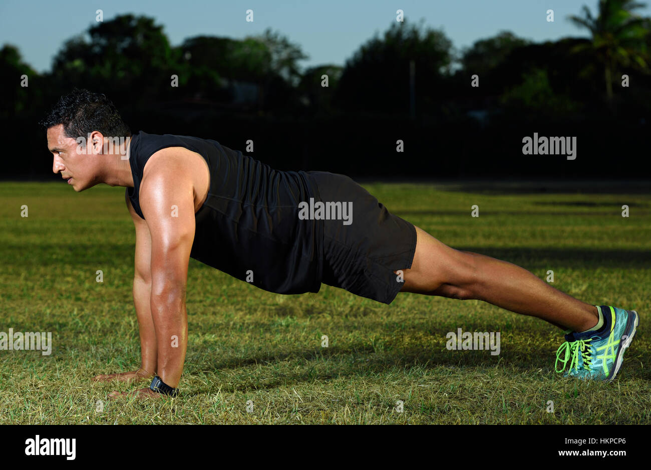 sport man doing push up on park green grass Stock Photo
