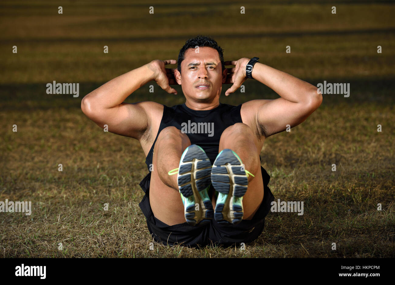 sport man doing exercise abs on grass park Stock Photo