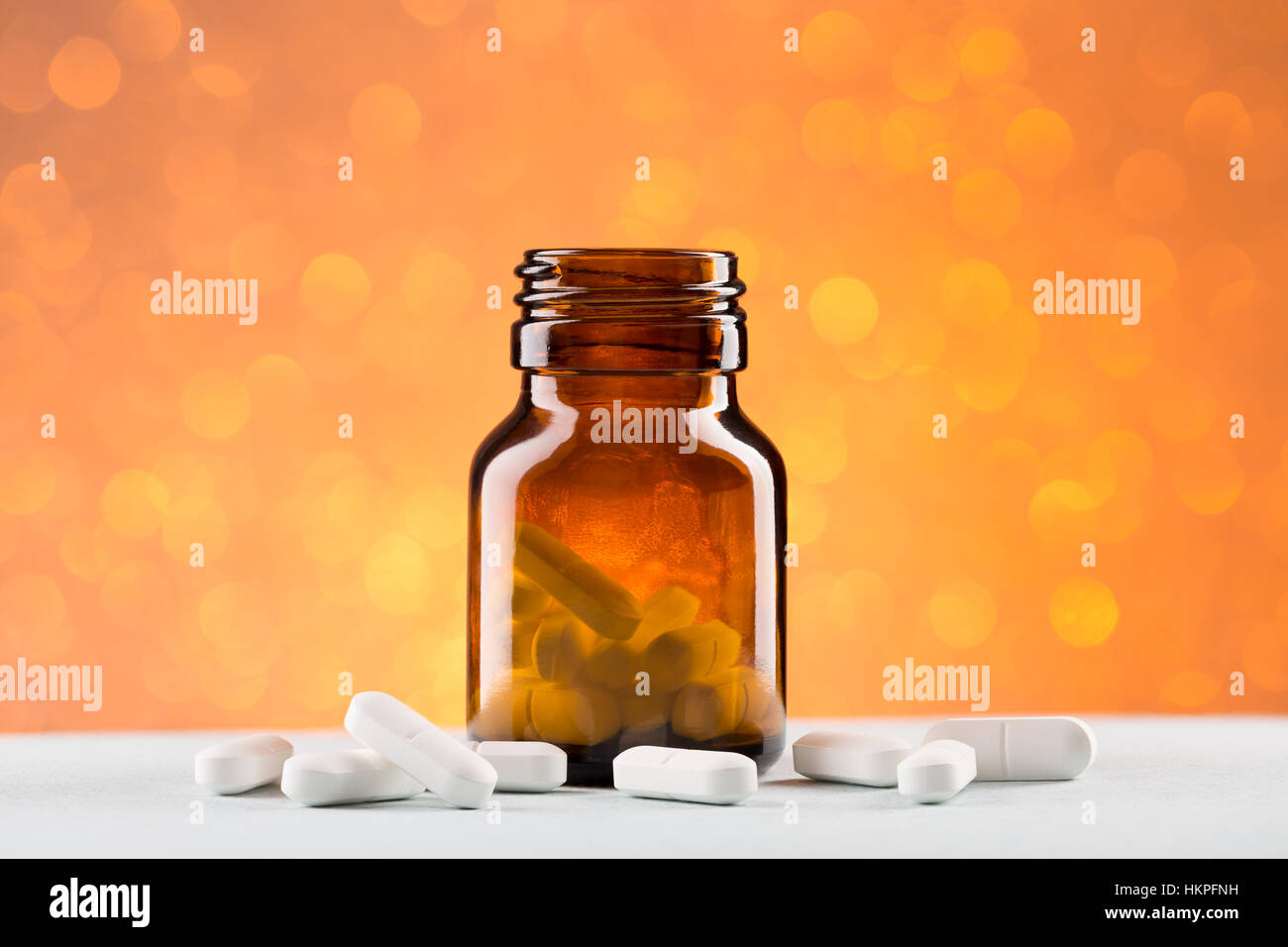 Glass pill bottle and white pills Stock Photo