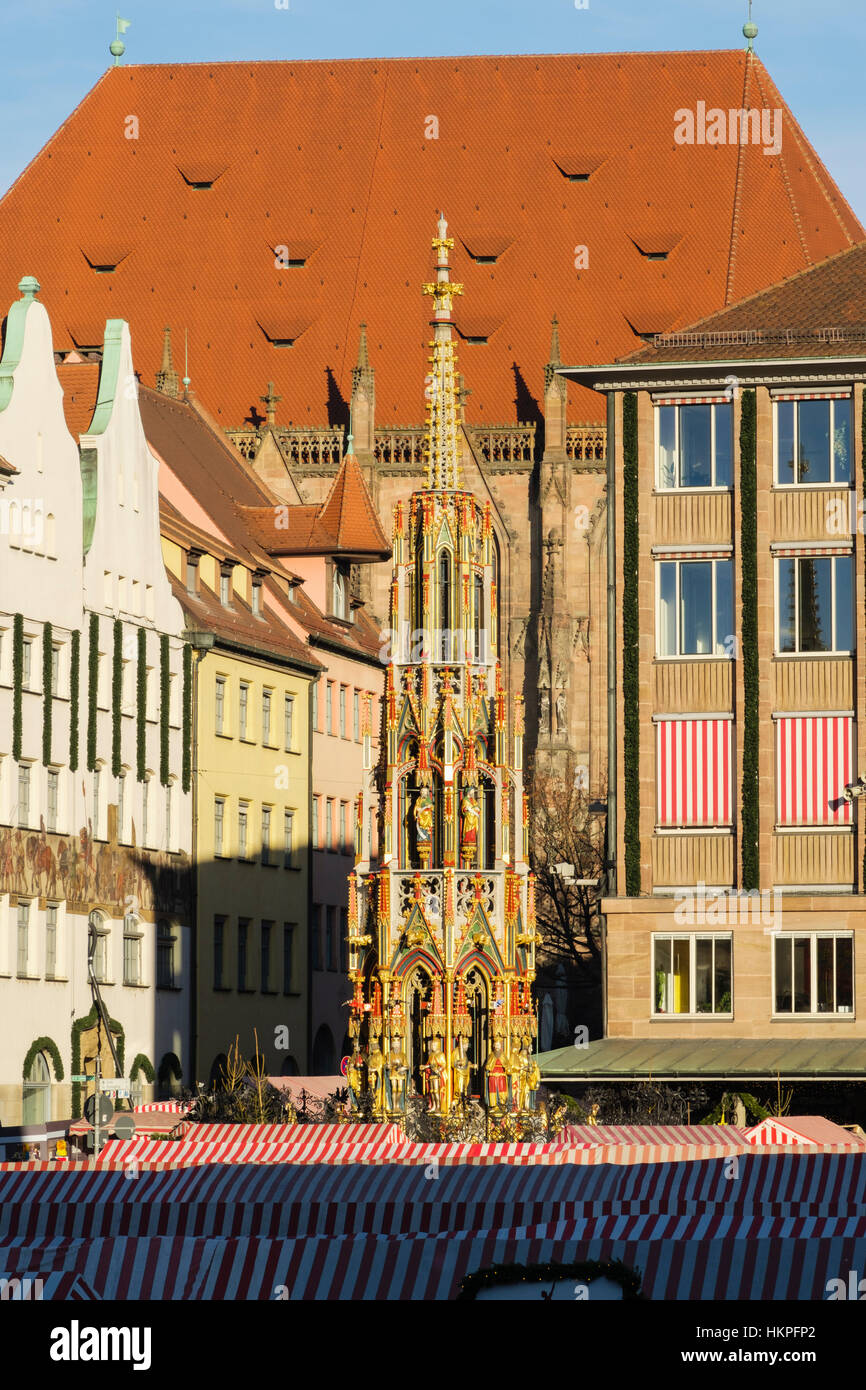View across Christmas market stalls to Schoene Brunnen or Beautiful Fountain in Hauptmarkt Square. Nuremberg, Bavaria, Germany Stock Photo