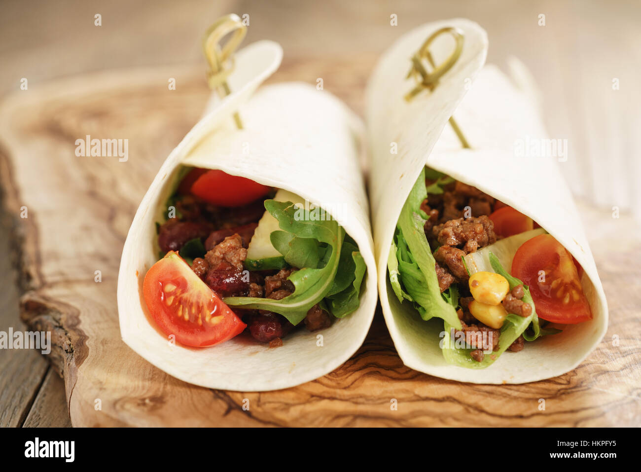 homemade tortilla wrap sandwiches with beef and vegetables on olive board Stock Photo