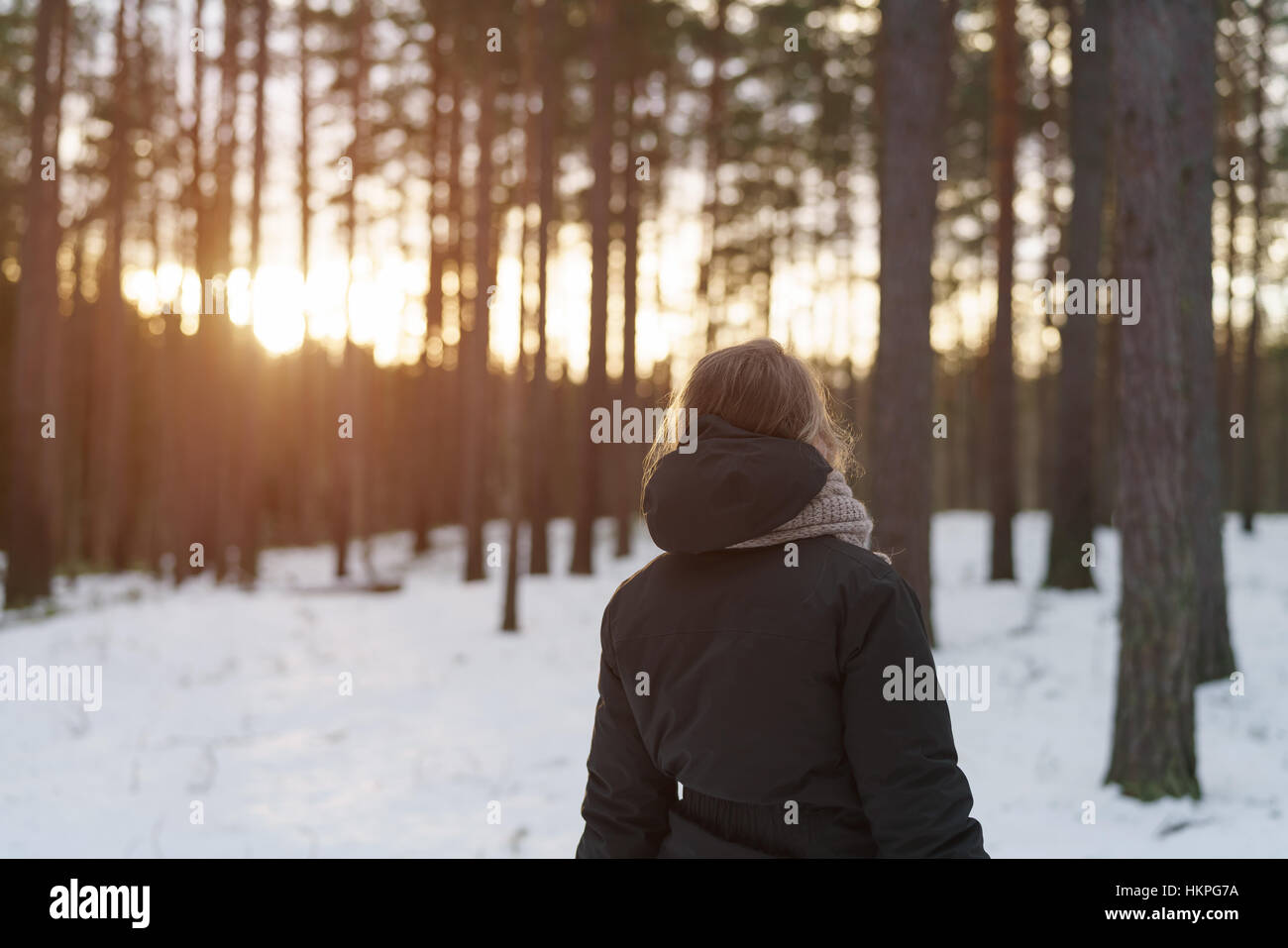 Женщина в зимнем лесу со спины
