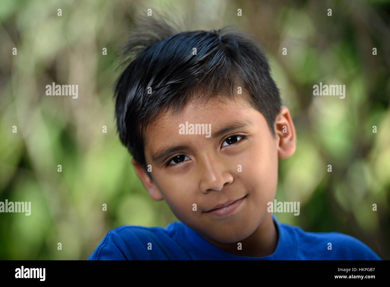 Headshot of latino boy with smile in garden Stock Photo