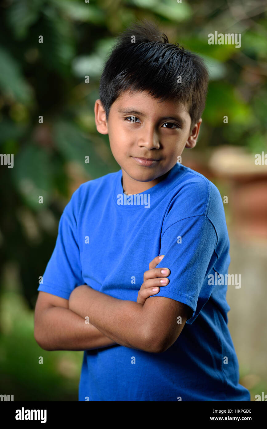 latino boy crossed arms in green background Stock Photo