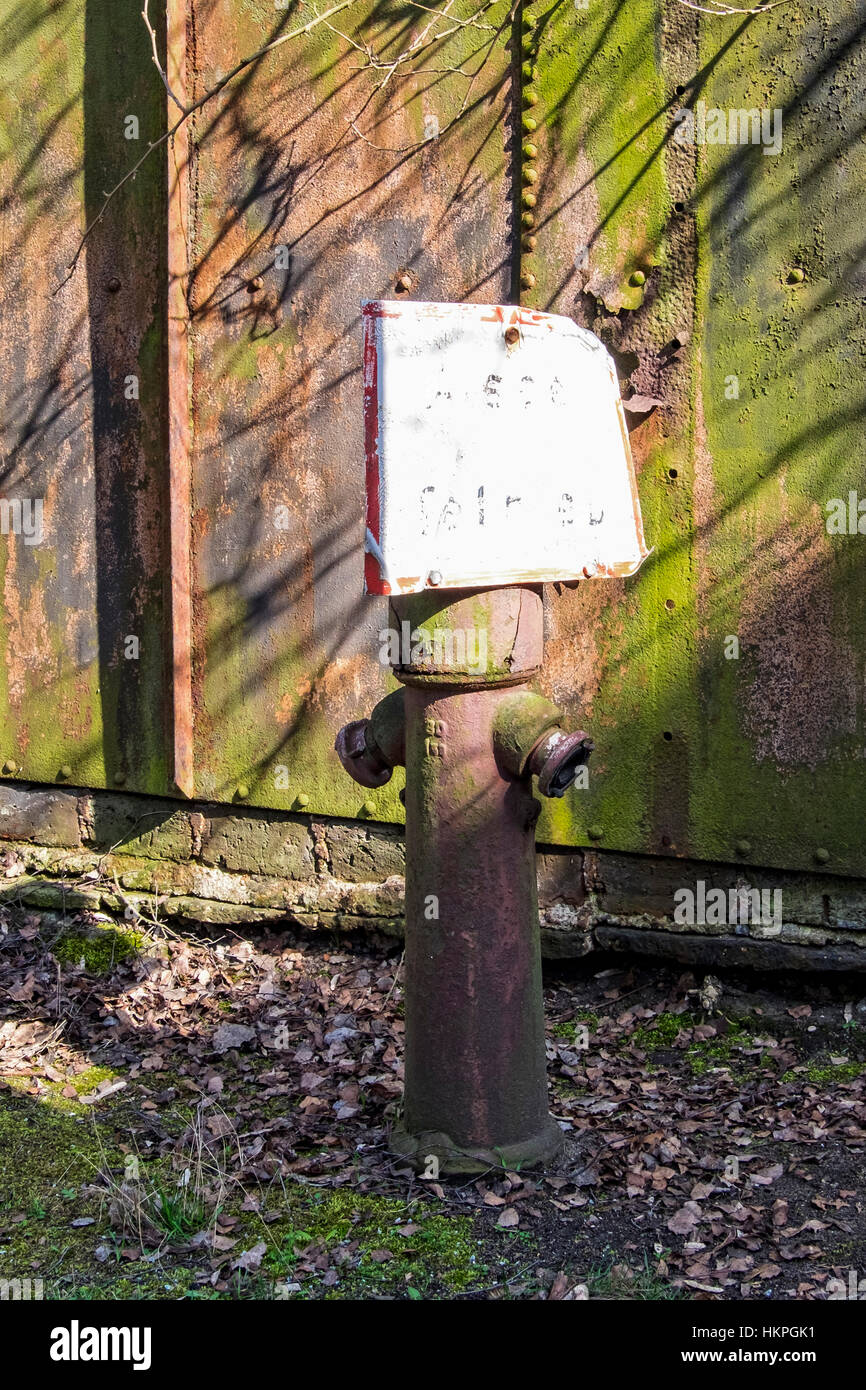 Old fire hydrant and rusty wall at the old Tempelhof train depot Natur-Park Schöneberger Südgelände Nature Park, Berlin Stock Photo