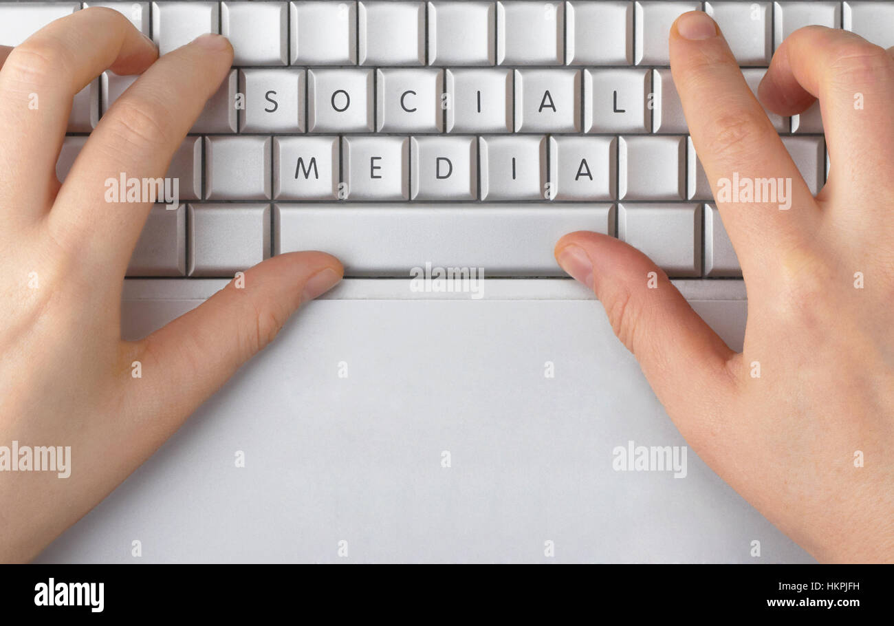 Hands typing on a silver laptop keyboard. The letters on the keys have been  erased and rearranged to spell only "social media Stock Photo - Alamy
