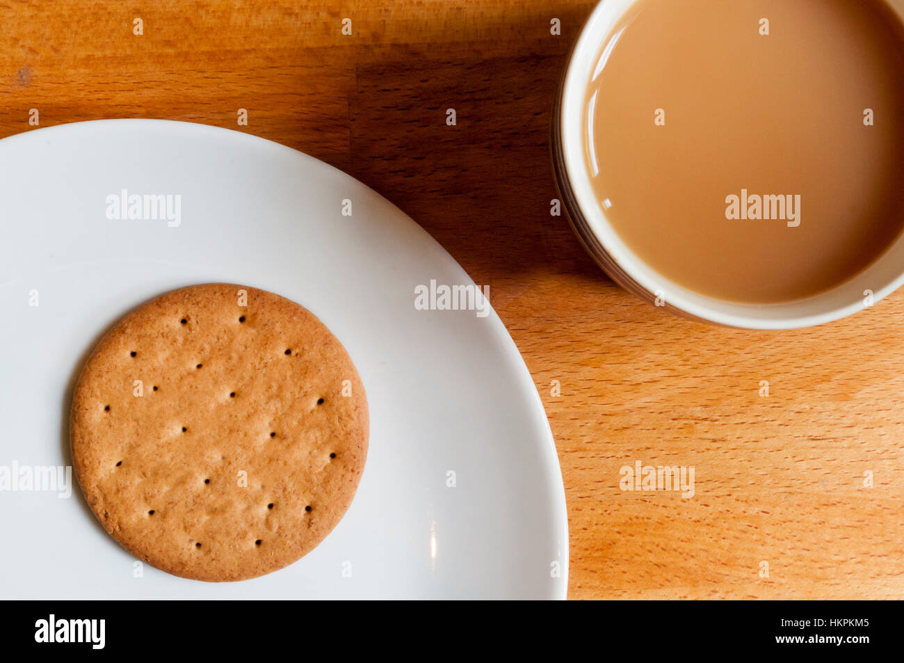 A mug of tea and a digestive biscuit. Stock Photo