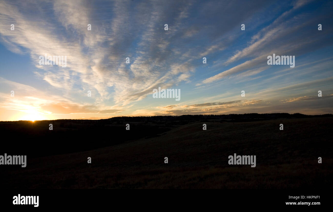 Dusk with clouds in the sky and trees in the background in Wyoming Stock Photo