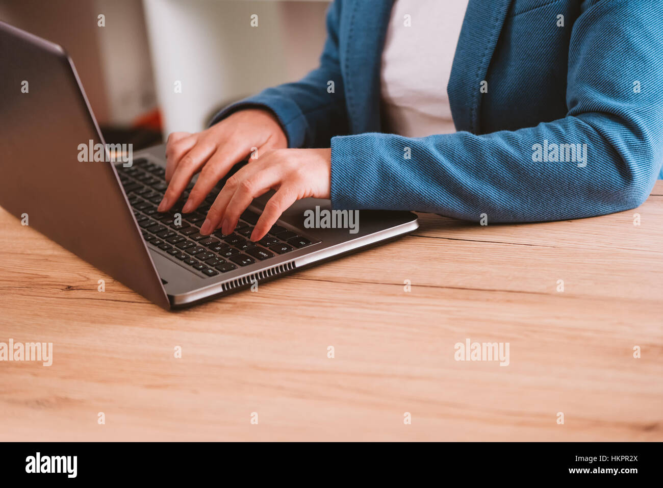 Businesswoman typing laptop computer keyboard in the office, desk surface as copy space Stock Photo