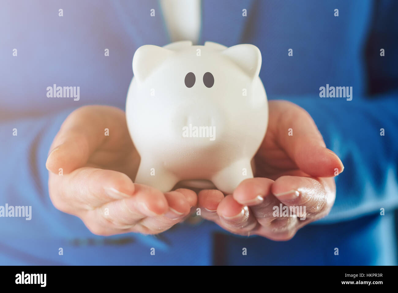 Piggy coin bank in hands of businesswoman, concept of responsible money management, saving and budgeting Stock Photo