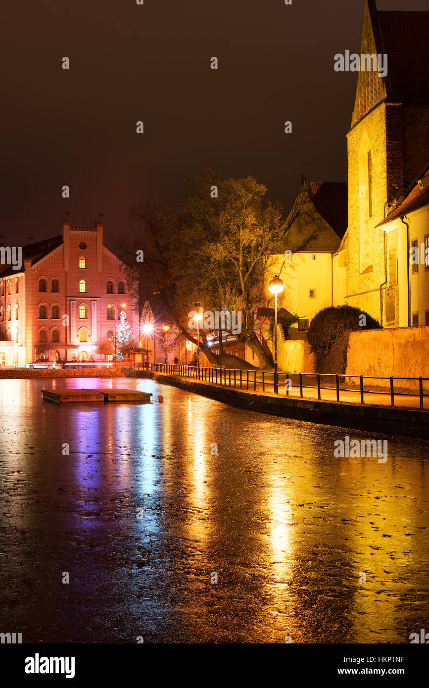 CESKE BUDEJOVICE, CZECH REPUBLIC - DECEMBER 15, 2016: Night architecture in the city with Budweis hotel. Old church on the bank of river. Ceske Budejo Stock Photo