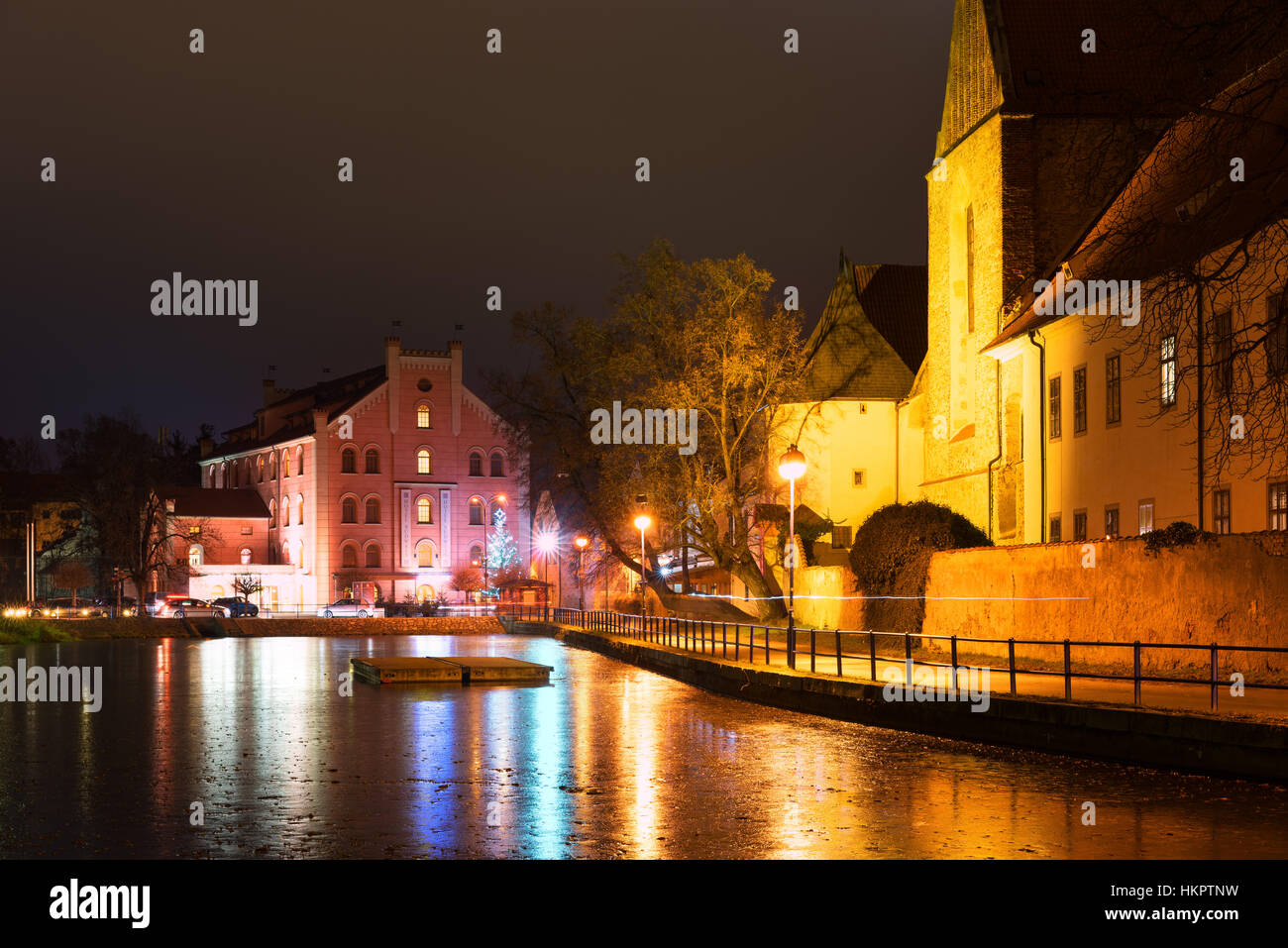 CESKE BUDEJOVICE, CZECH REPUBLIC - DECEMBER 15, 2016: Night architecture in the city with Budweis hotel. Old church on the bank of river. Ceske Budejo Stock Photo