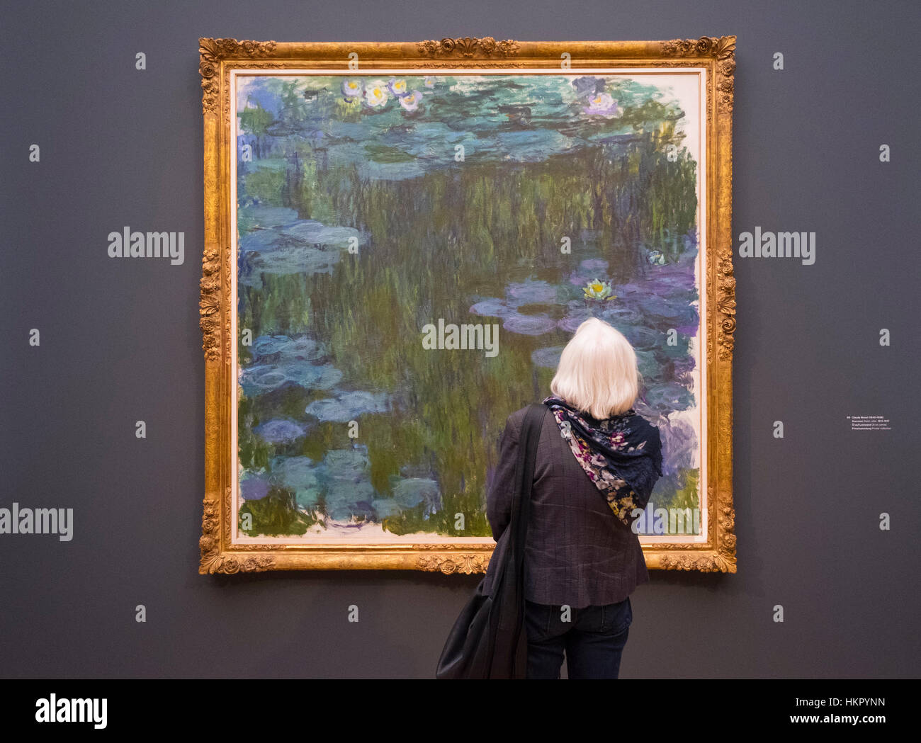 Visitor looking at painting, The Water Lily Pond by Claude Monet 