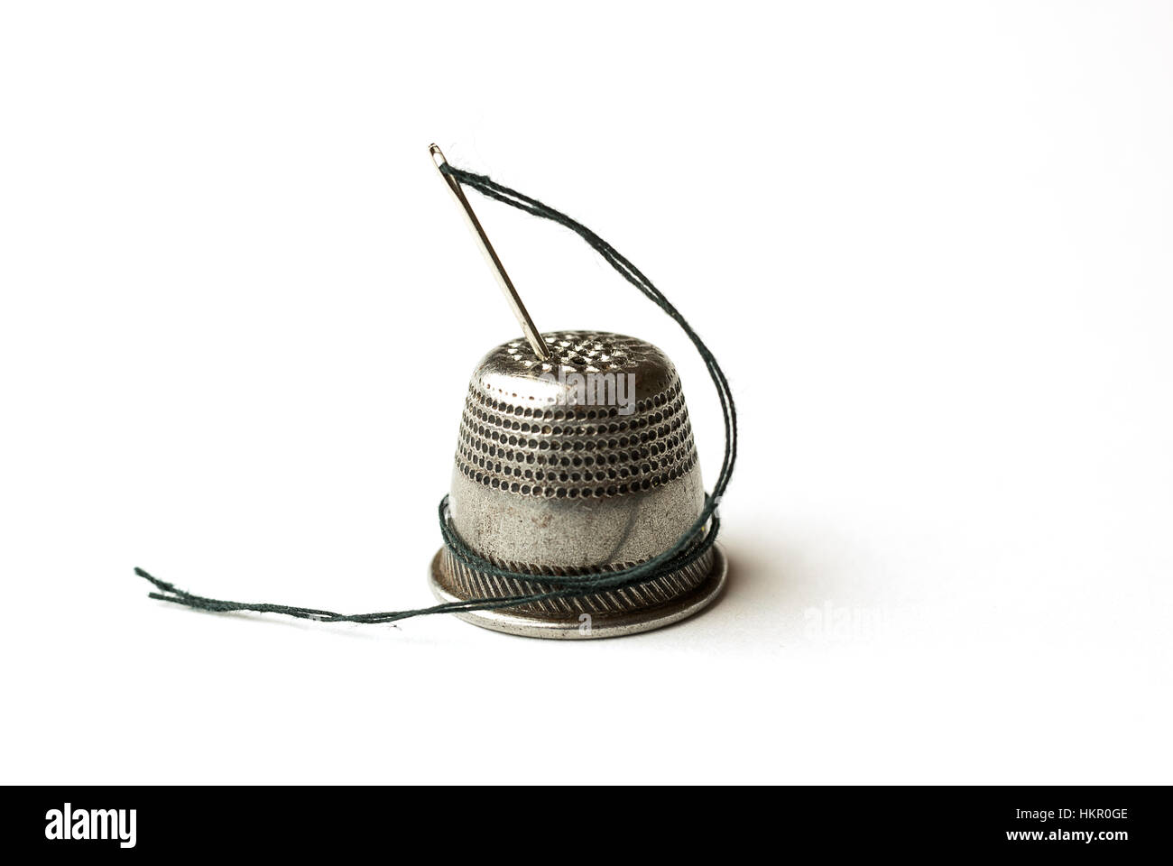 Metal thimble and needle with thread on over white Stock Photo Alamy