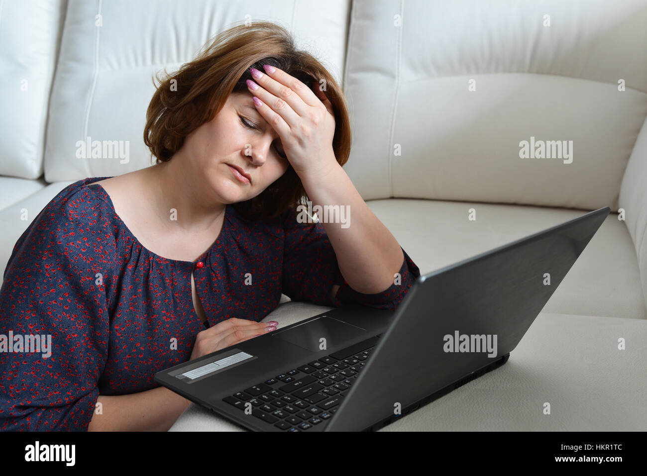 Woman with headache uses a computer at home Stock Photo Alamy