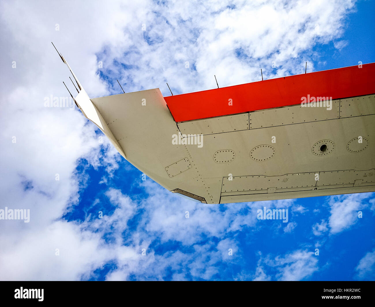 Airplane wing on blue sky from below as background Stock Photo