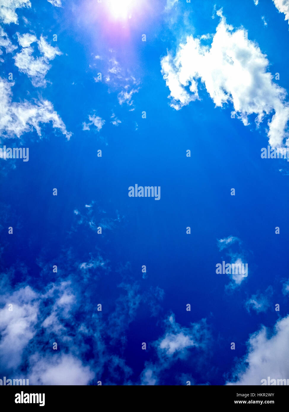 Beautiful blue sky with clouds and sun as background Stock Photo