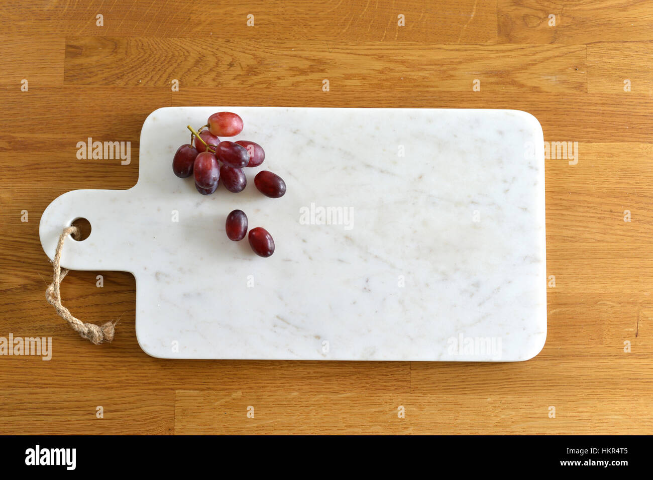 White marble cheese board in a kitchen with cheese and grapes Stock Photo