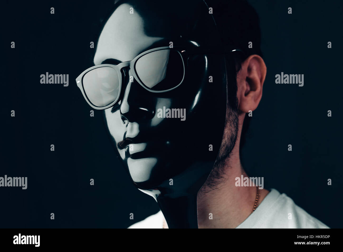 Man in glossy black mask and sunglasses. Studio horizontal portrait in ...