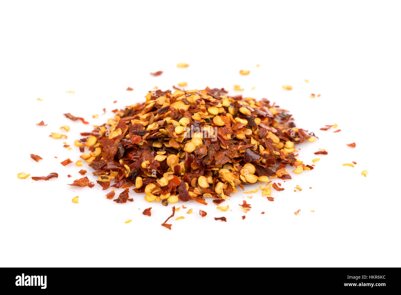 The pile of a crushed red pepper, dried chili flakes and seeds isolated