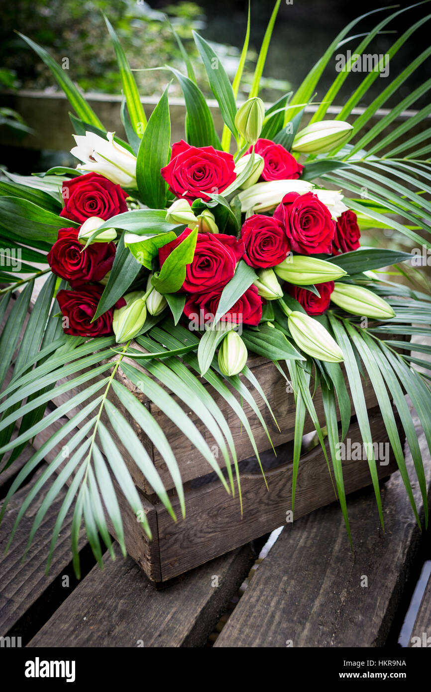 Red Roses, Lilies and palm flower display Stock Photo