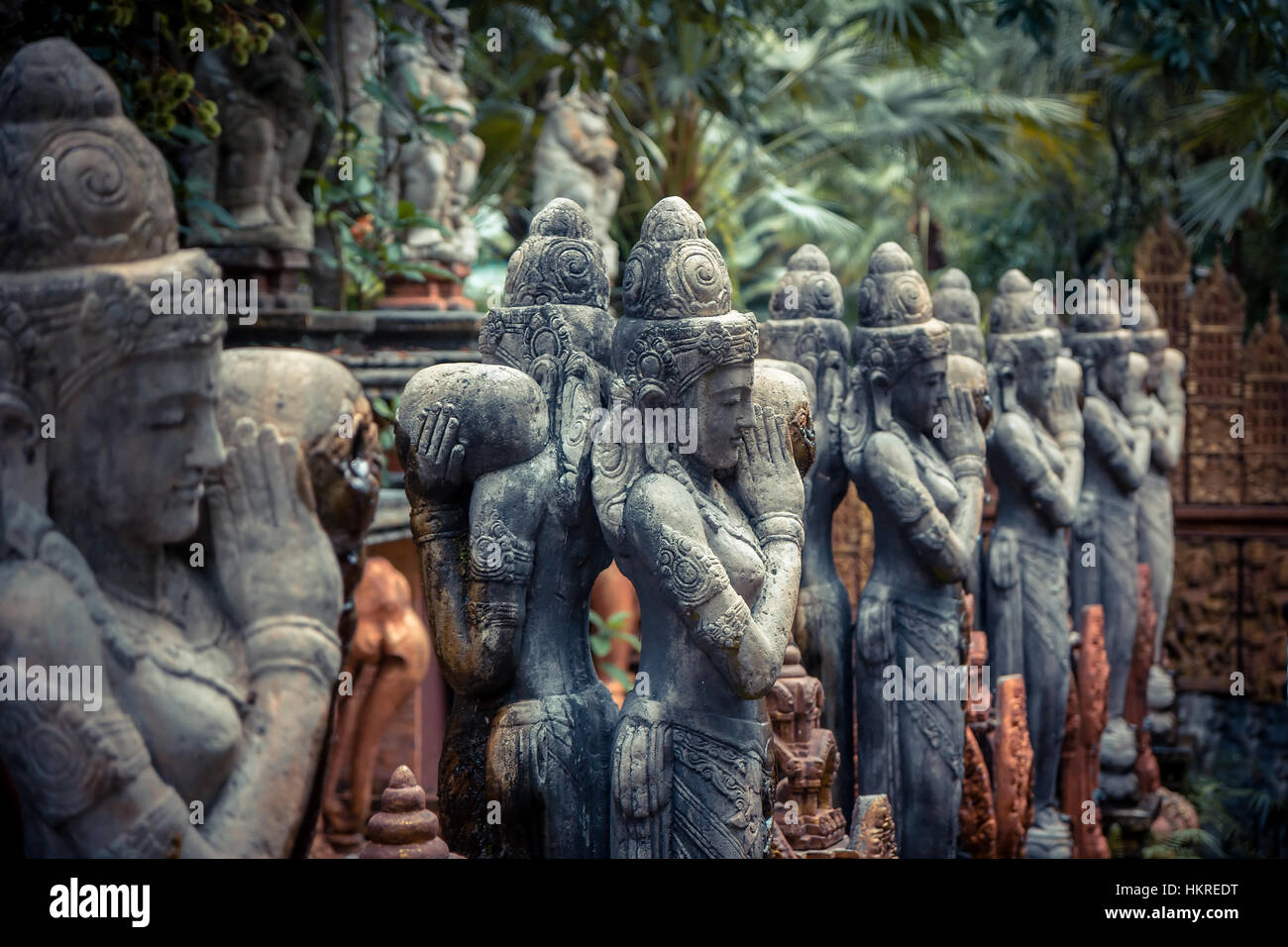 Traditional Asian sculptures of Buddhism deities in vintage style in tropical garden illustrating Asian culture and Asian carvin Stock Photo