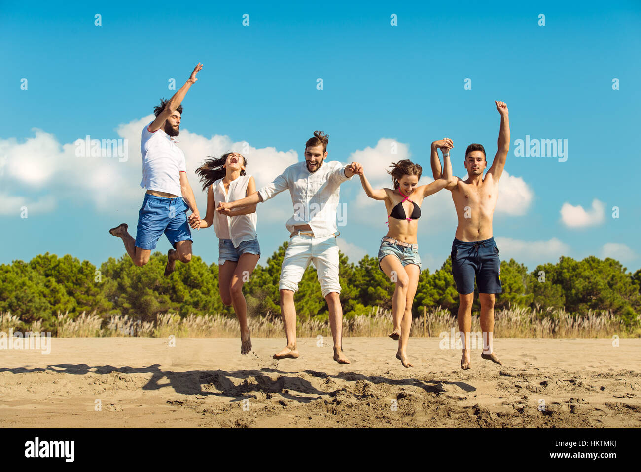 Group of friends together on the beach having fun Stock Photo - Alamy