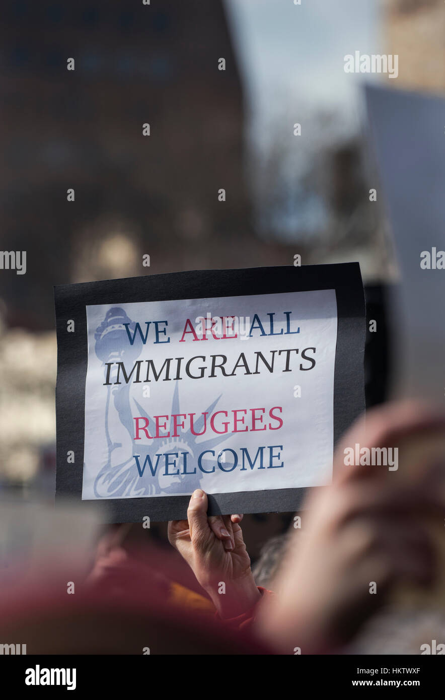 Boston, Massachusetts, USA. 29th January, 2017.  More than 20,000 demonstrators filled Copley Square in central Boston protesting President Donald Trump’s executive order stopped immigration from Iran, Iraq, Yemen, Somalia, Sudan, Libya and Syria to the United States.  Photo shows a hand holding a small protest sign supporting Immigrants.   The demonstration in Copley Square was organized by the Massachusetts branch of the Council on American-Islamic Relations, CAIR.  Credit: Chuck Nacke/Alamy Live News Stock Photo