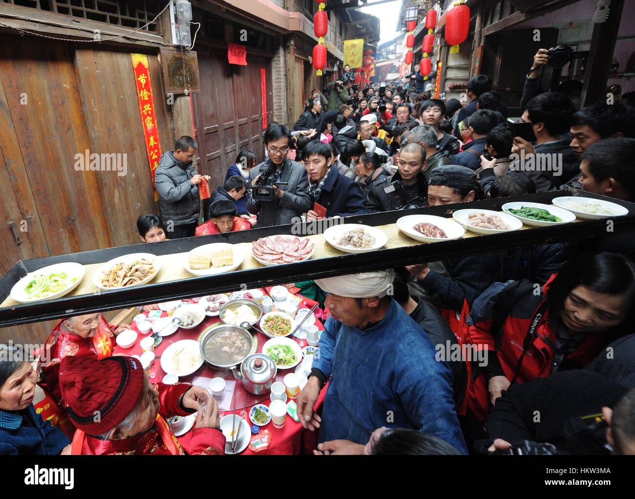 Beijing, China. 7th Feb, 2013. File photo taken on Feb. 7, 2013 shows a man carrying a tray with dishes of delicacies on his head during a traditional Lunar New Year banquet in Zhongshan Township of southwest China's Chongqing Municipality. The most important spirit of Chinese lunar New Year, or Spring Festival, is family reunion. It is also the most happiest time in all ages for Chinese people to get together to enjoy delicious food. Credit: Li Jian/Xinhua/Alamy Live News Stock Photo