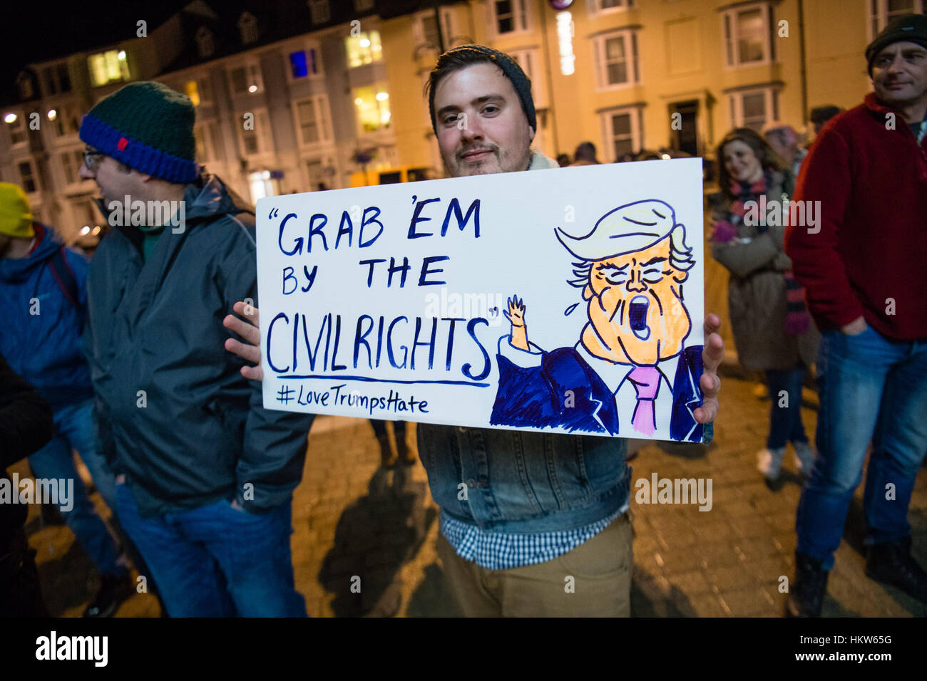 PROTESTING AGAINST DONALD TRUMP: Aberystwyth, Wales, UK. 30th Jan, 2017. Around 300 people of all ages and from a wide range of backgrounds gathered, many carrying banners, outside the seaside bandstand in Aberystwyth at 6pm tonight, Monday 30 Jan, to protest against the Executive Order signed by President Donald Trump banning entry into the USA for refugees from Syria and other people from seven primarily Muslim countries in the middle east photo Credit: keith morris/Alamy Live News Stock Photo