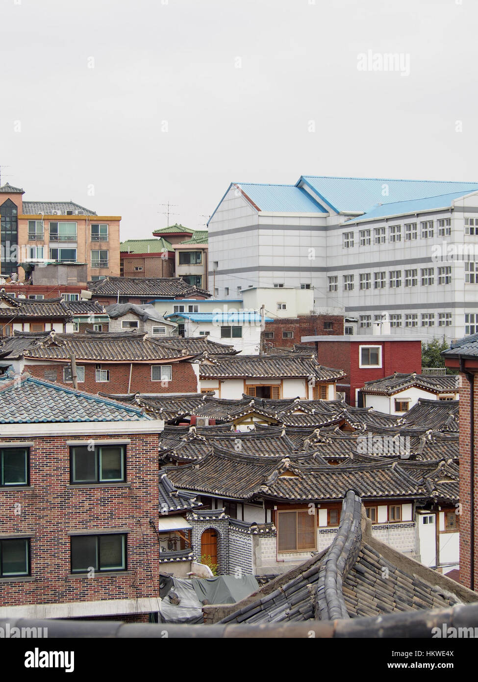 Traditional rooftops of a hanok village in downtown Seoul contrasts ...