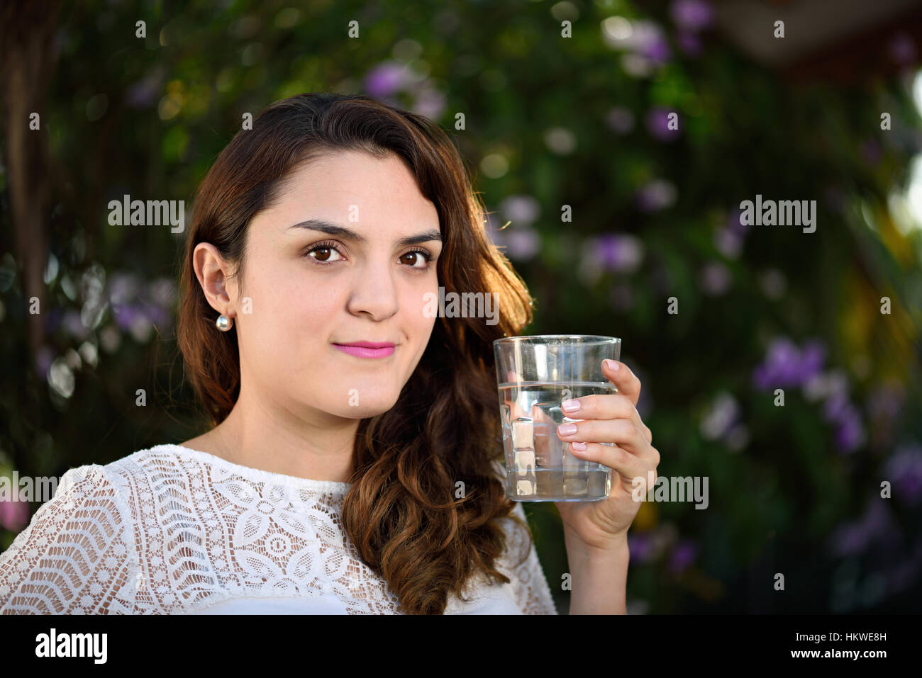 girl with glass of water in green park background Stock Photo