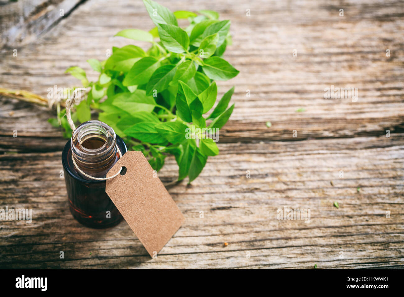Fresh basil twig and oil on wooden background Stock Photo - Alamy