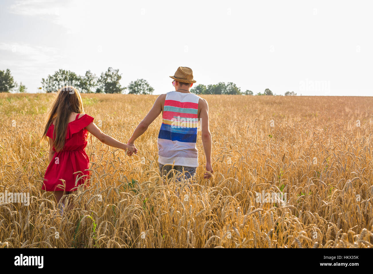 Back view of amorous couple walking in the field Stock Photo - Alamy