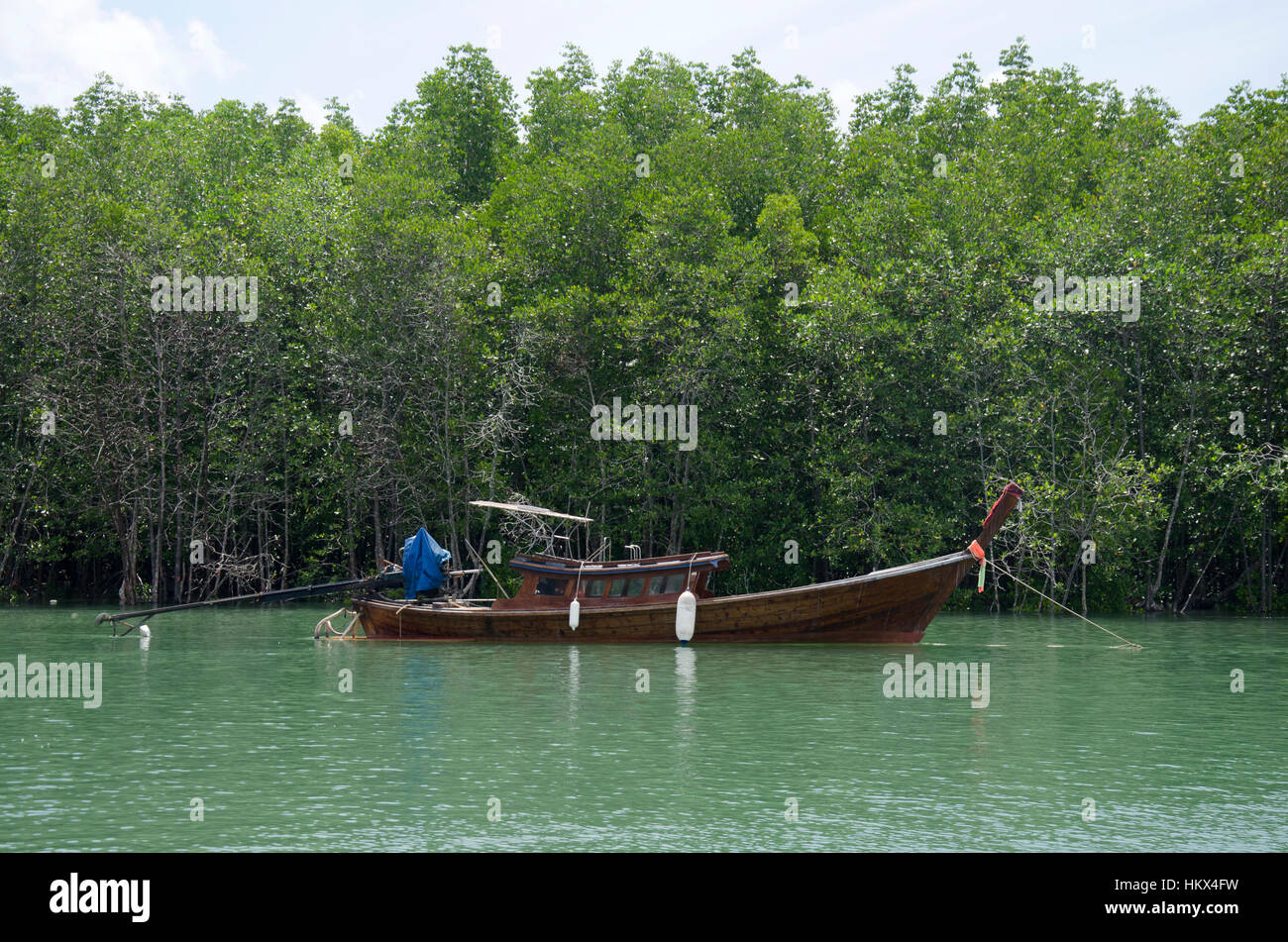 Asian thai people stop Classic wooden boat on the sea near Mangrove forest or Intertidal forest at the estuary of a river at Bang Rong Pier in Phuket, Stock Photo